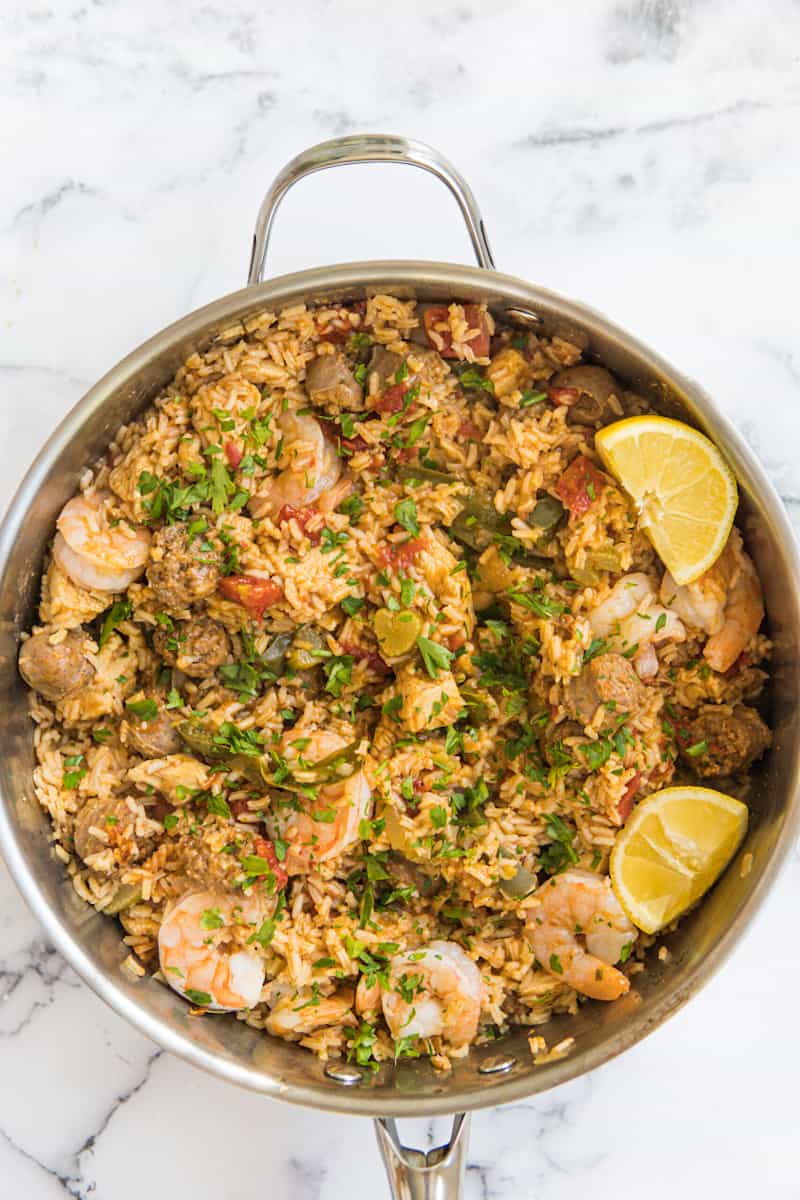 This Jambalaya Dutch Oven is made with sausage, shrimp, chicken, lots of seasonings, tomatoes, rice, and chicken broth.
