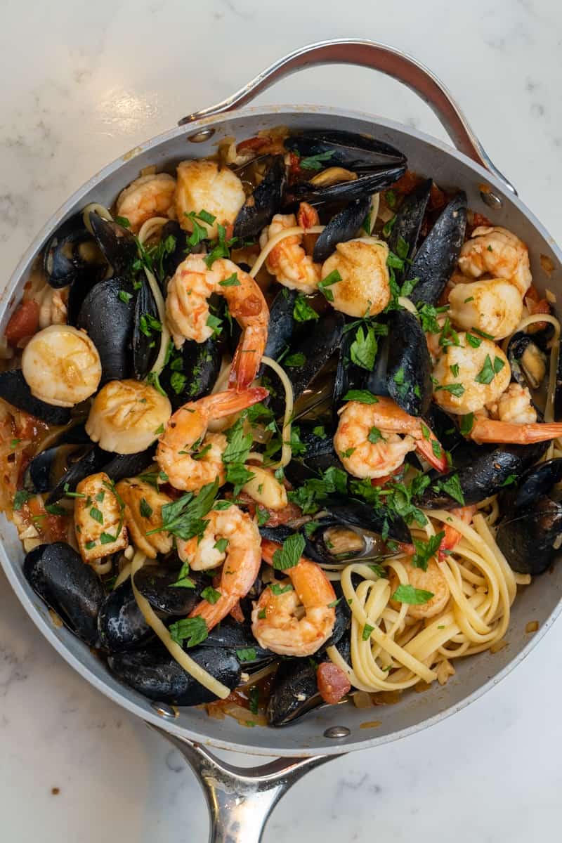 This Linguini Frutti di Mare is made with mussels, scallops, shrimp, garlic, onion, tomatoes, parsley, and freshly cooked linguini.