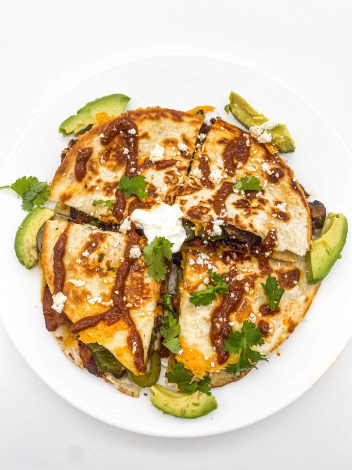 This Portobello and Bacon Quesadillas with Chipotle Aioli is made with chipotle sauce, avocado, flour tortillas, cilantro, and sour cream.
