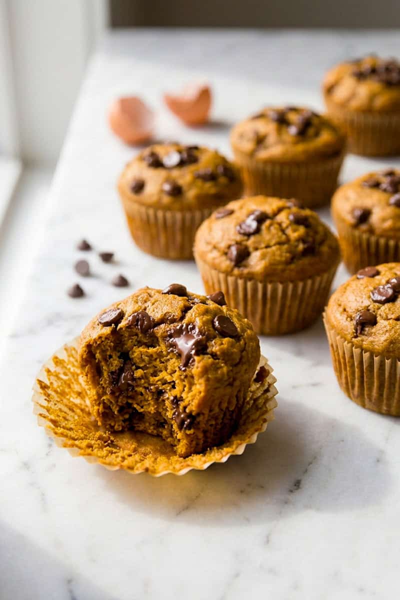 Moist pumpkin chocolate chip muffins stacked on a serving plate