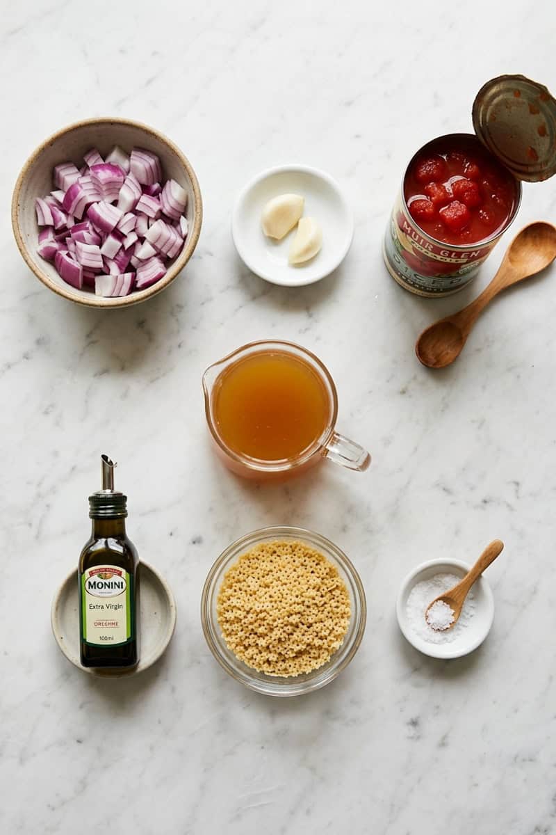 Tomatoes, star pasta, red onion, garlic, broth and olive oil for sopa de estrellas