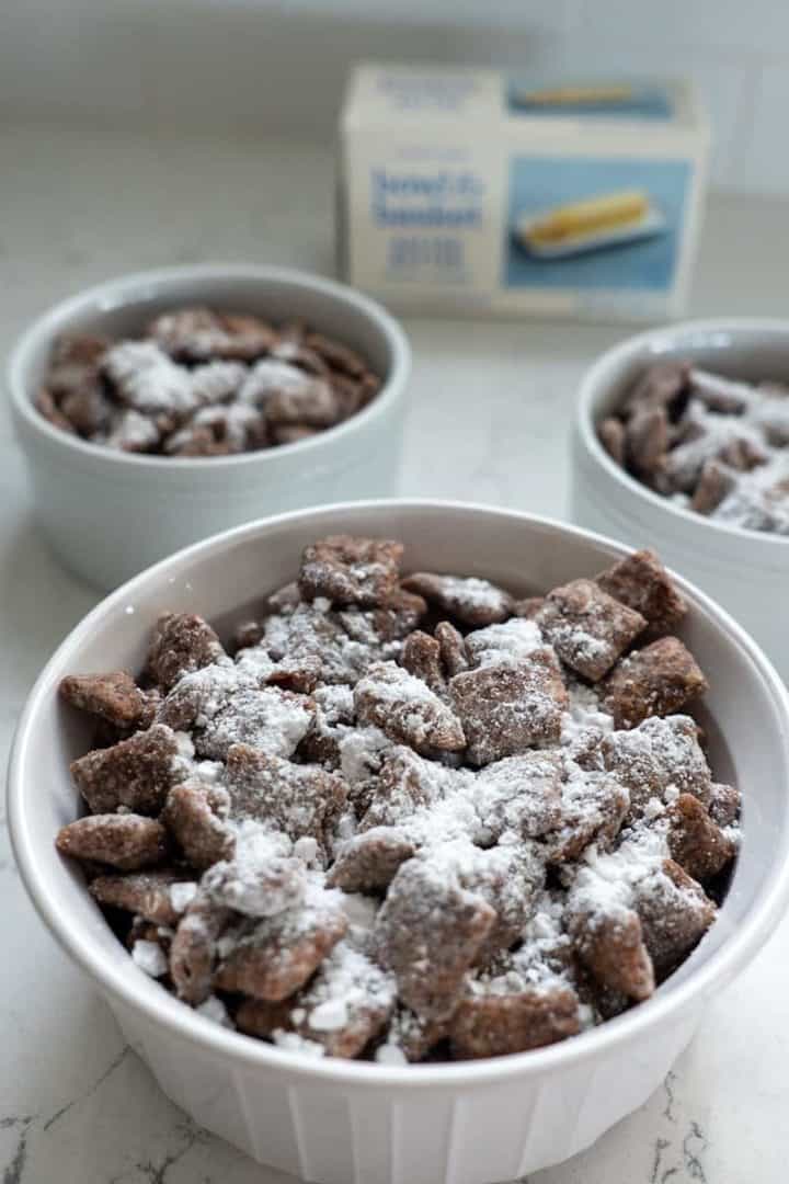 These Cookie Butter Puppy Chow are made with Rice Chex, semisweet chocolate chips, Pillsbury Sugar Cookie Dough, vanilla extract, salted butter, and powdered sugar.