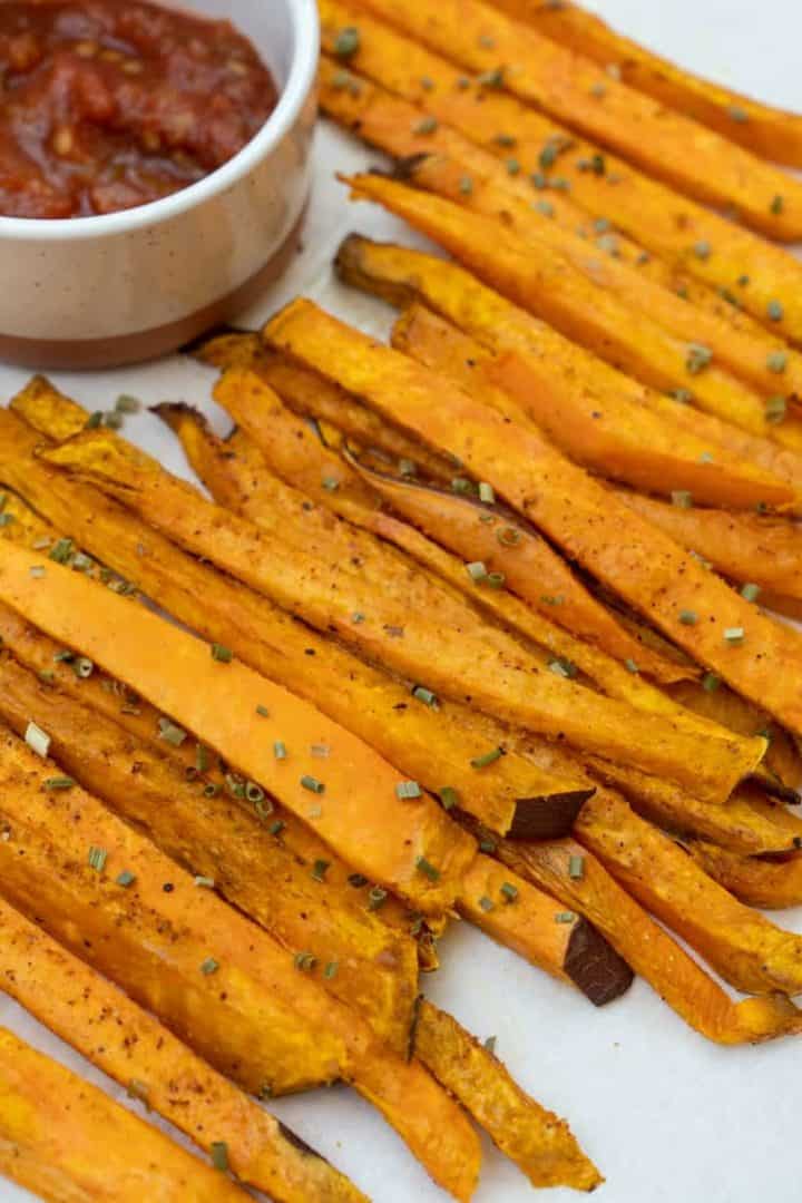 This Air Fryer Sweet Potato Fries Recipe is made of sweet potatoes, avocado oil spray, chives, Cajun seasoning, smoked paprika, and salt.