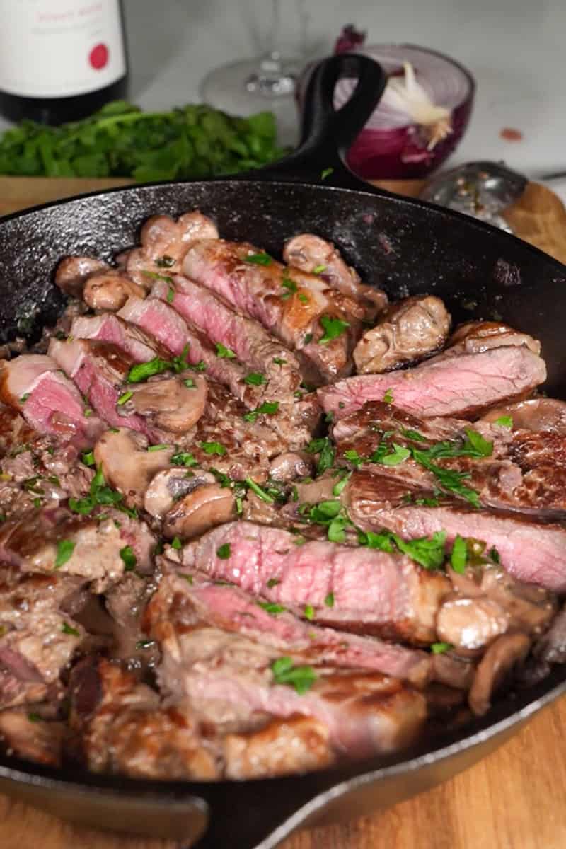 Pan-seared steak served with creamy mushrooms and fresh parsley
