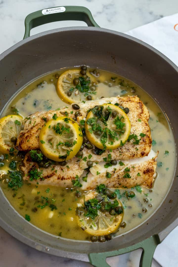 This Pan Seared Halibut Recipe is made with halibut, butter, olive oil, lemons, garlic, white wine, capers and garnished with fresh parsley.