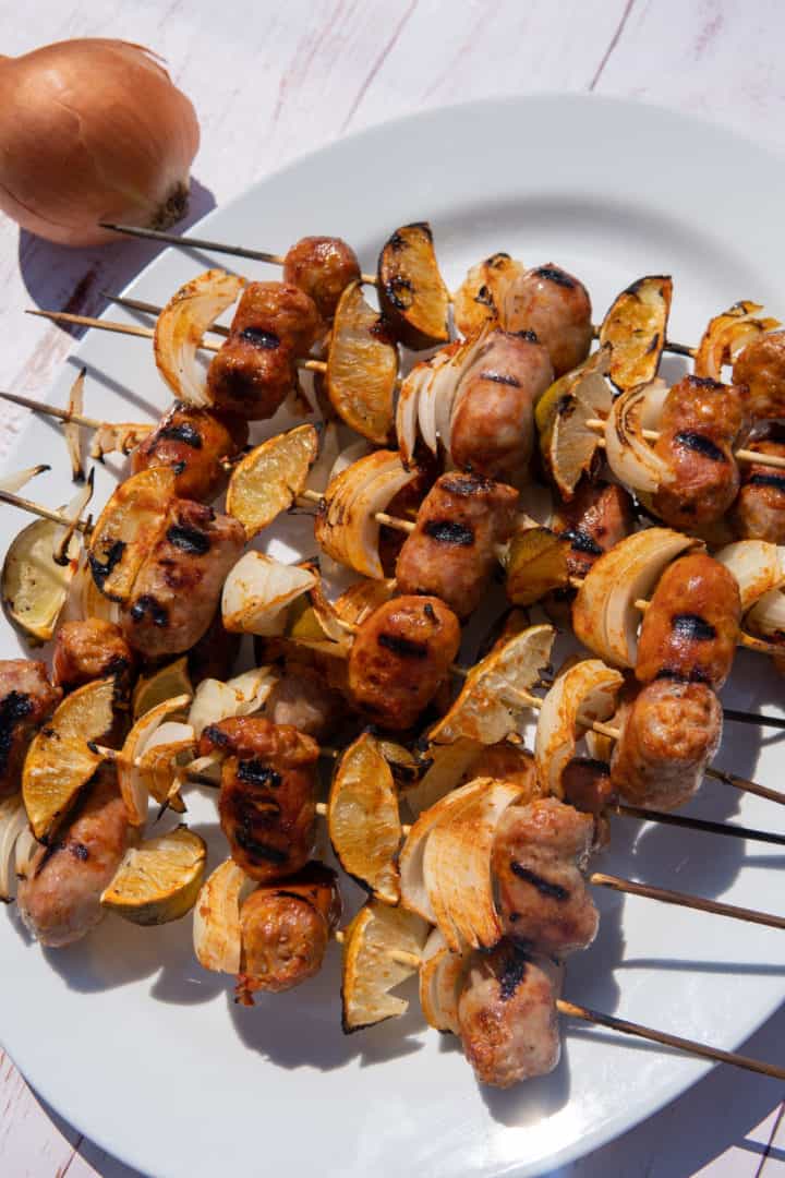 These Sausage and Lime Skewers are made with sausage, red onion, limes, skewers and drenched in a garlic chili sauce. 