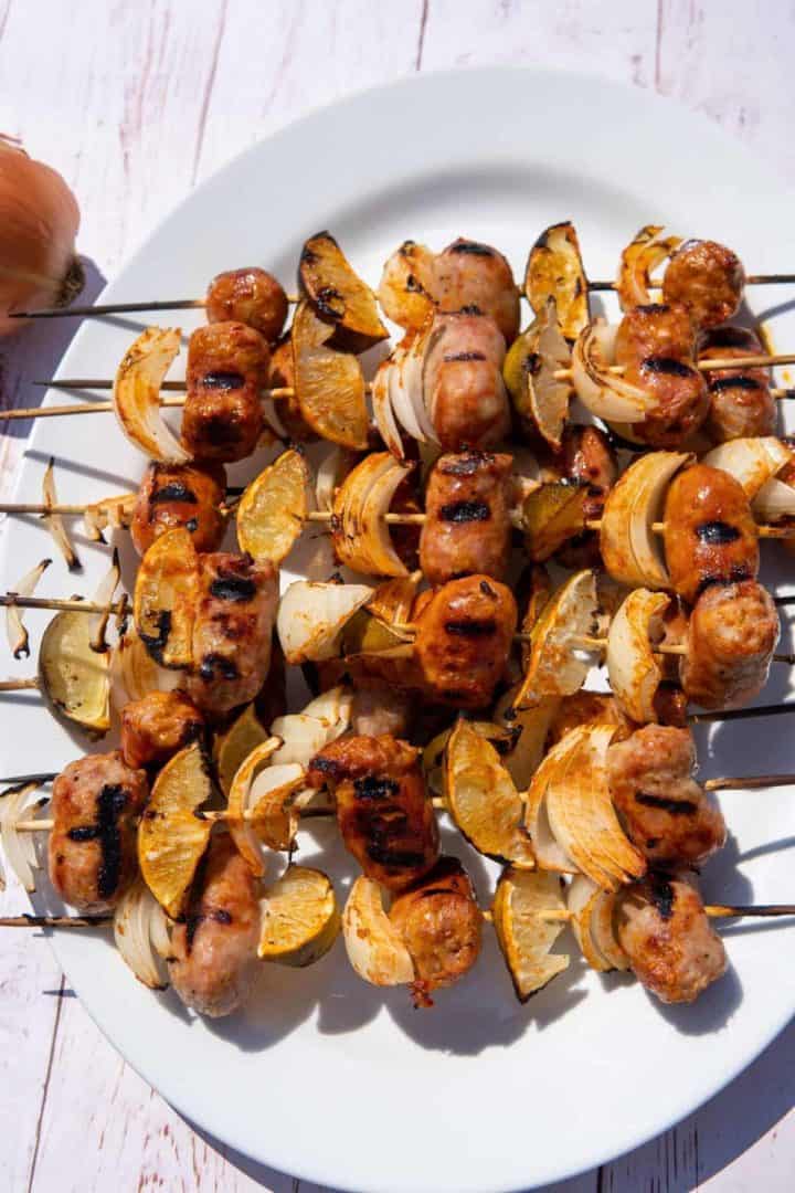 These Sausage Skewers Appetizers are made with sausage, red onion, limes, skewers and drenched in a garlic chili sauce. 