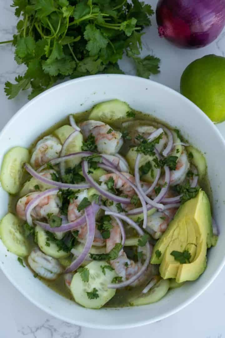 This Shrimp Aguachile Recipe is made with by blending jalapeños, limes, cilantro, which is poured over the shrimp and served with cucumber and onion.
