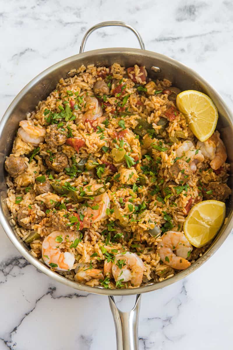 This Jambalaya Dutch Oven is made with sausage, shrimp, chicken, lots of seasonings, tomatoes, rice, and chicken broth.