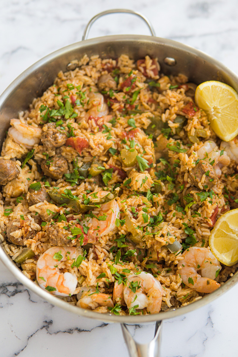 This Jambalaya Dutch Oven is made with sausage, shrimp, chicken, lots of seasonings, tomatoes, rice, and chicken broth.