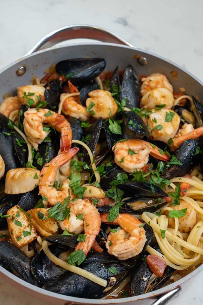 Esta Pasta con Mariscos (Mejillones, Vieiras y Camarones) está preparado con mariscos, ajo, cebolla, tomates, perejil y linguini.