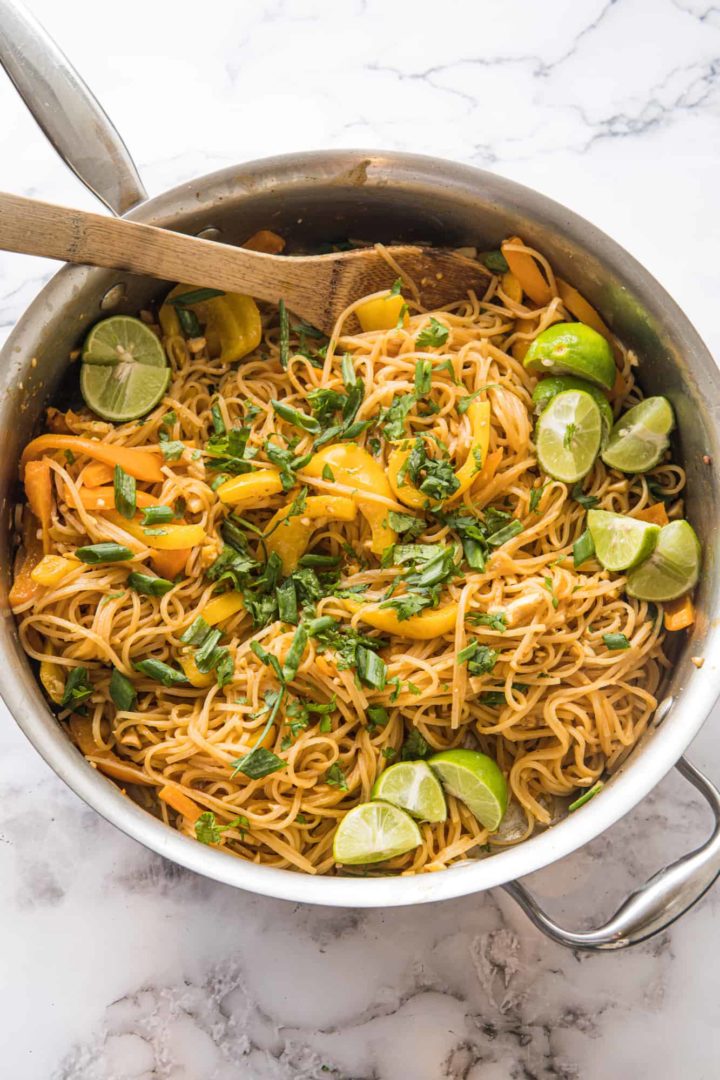 This Vegetable Pad Thai Recipe is made with rice noodles, garlic, ginger, eggs, bell pepper, peanuts, scallions, limes and cilantro.