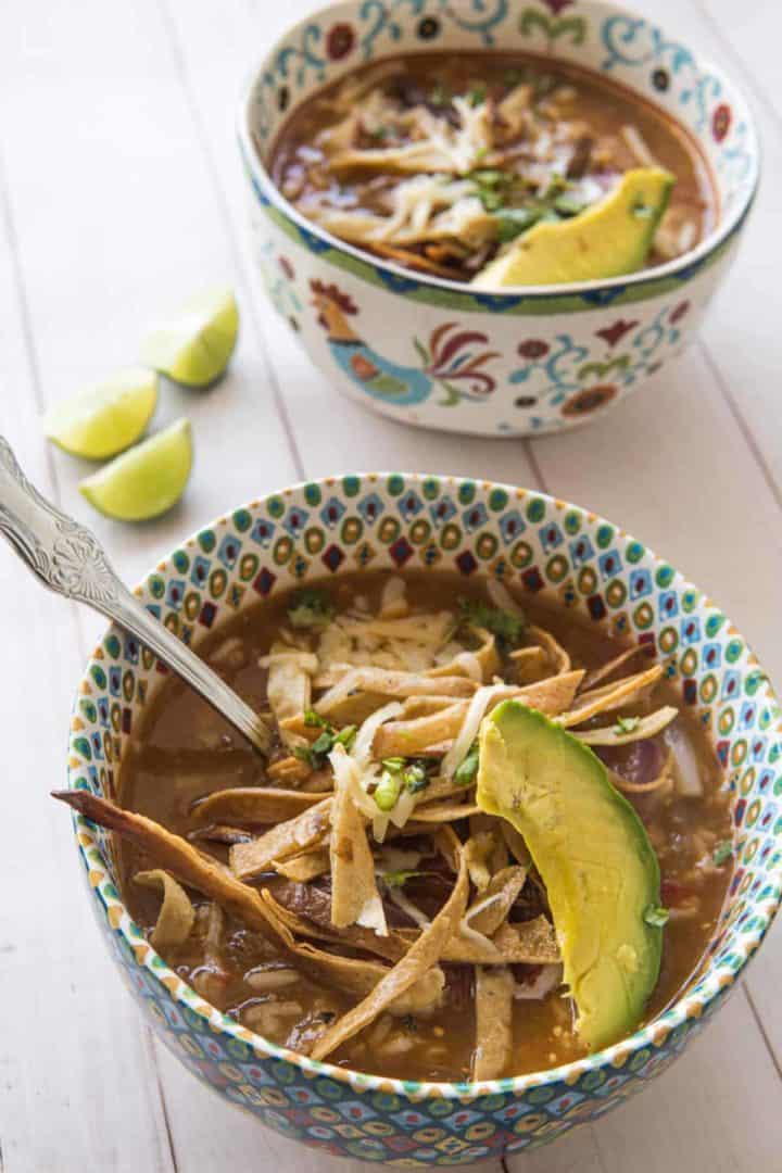 This Instant Pot Chicken Tortilla Soup is made with chicken, tomatoes, salsa verde, onion, garlic, rice, limes, cilantro and tortilla chips. 