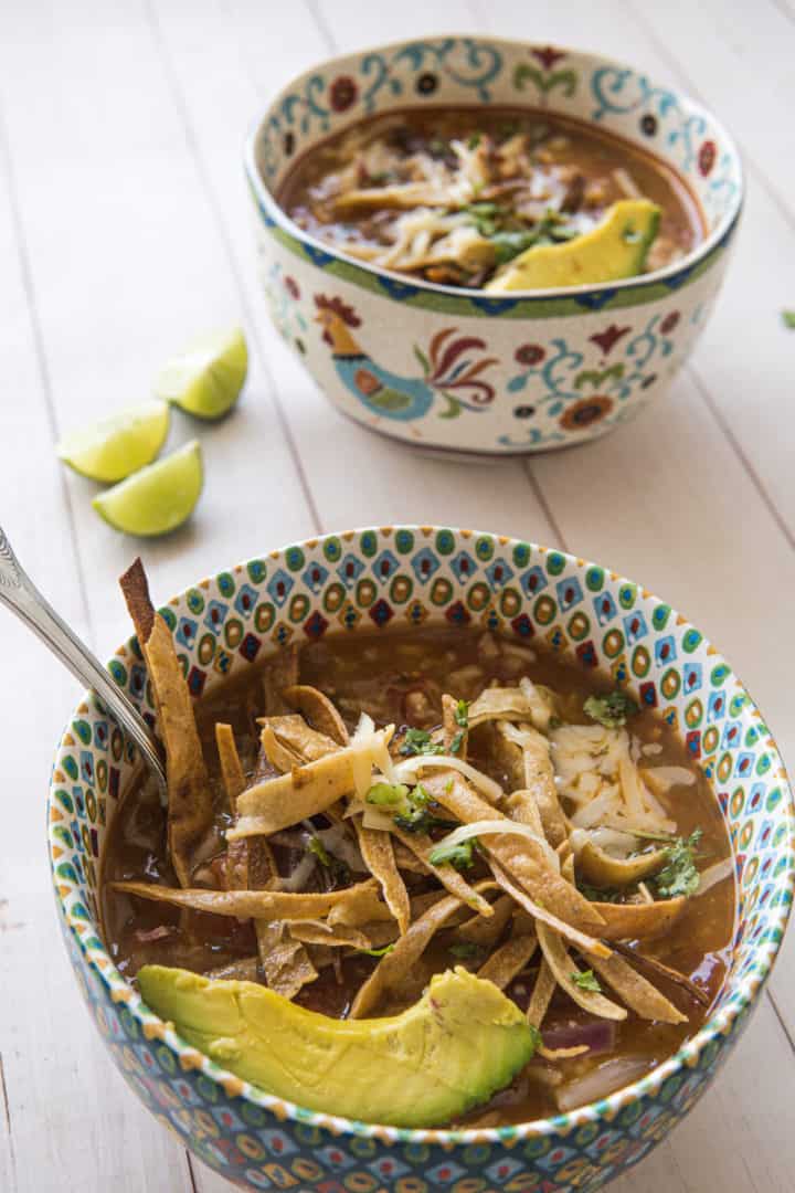 This Instant Pot Chicken Tortilla Soup is made with chicken, tomatoes, salsa verde, onion, garlic, rice, limes, cilantro and tortilla chips. 