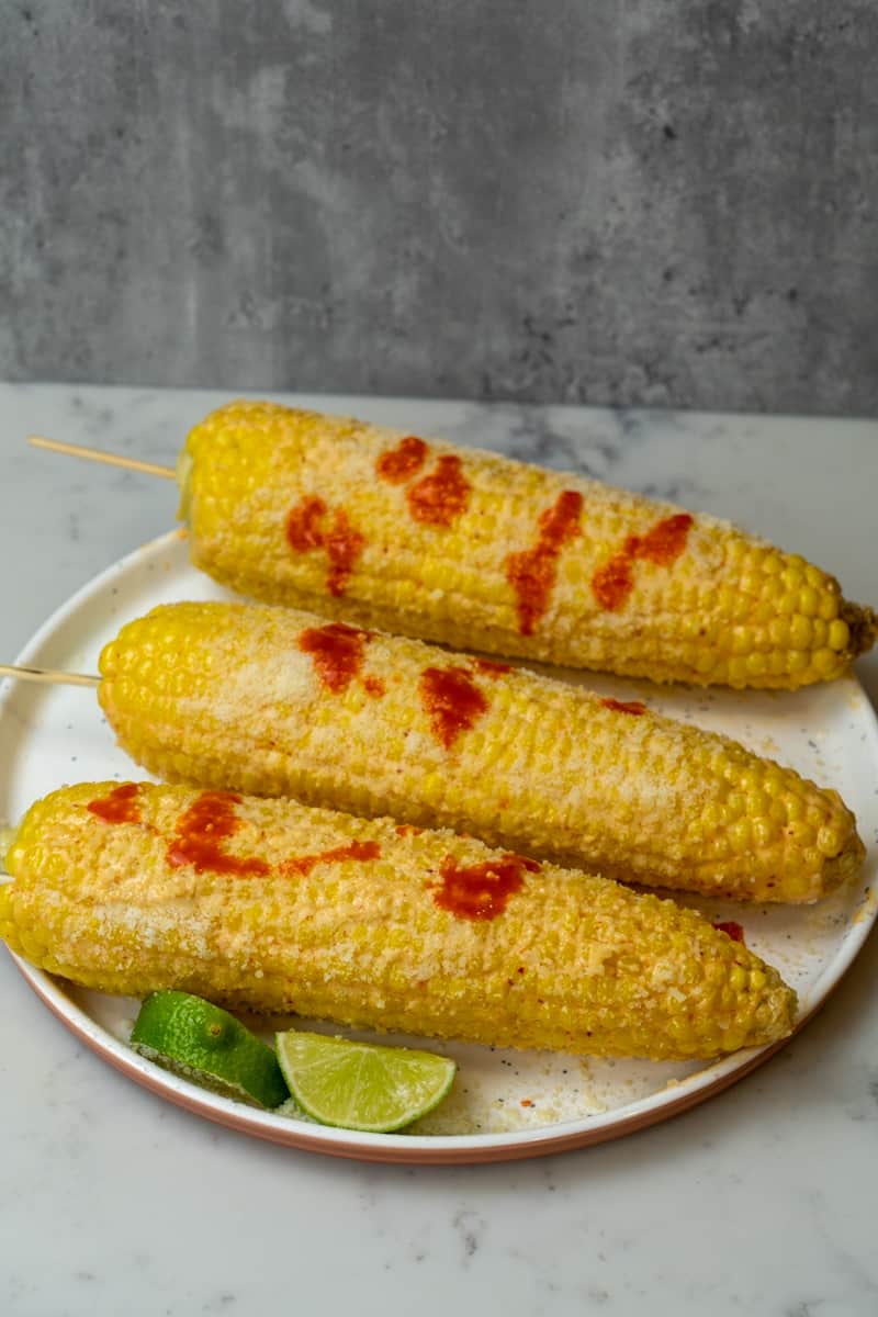 Sprinkle on cheese and serve with lime wedges. Enjoy this Mexican Corn Recipe (Elote Mexicano). 
