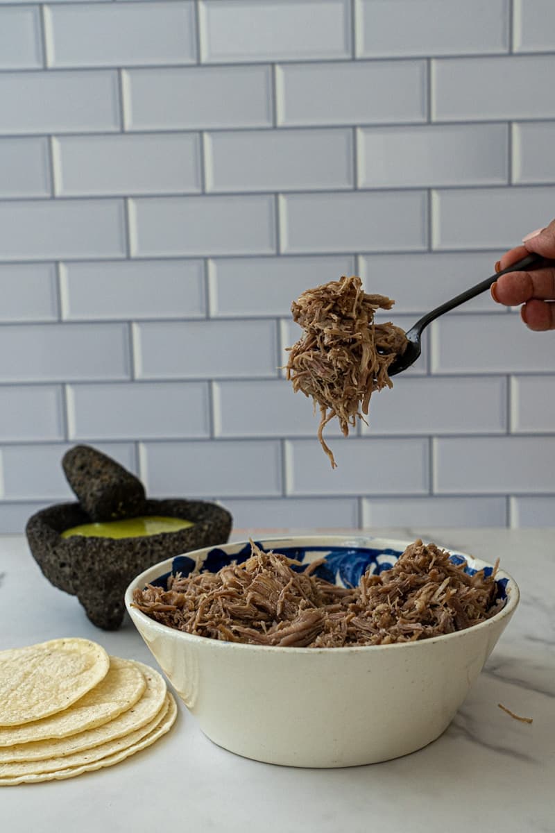 This Carnitas de Puerco recipe uses with pork butt, onion, limes, spices, and ancho chiles. This is the most flavorful Carnitas recipe ever!