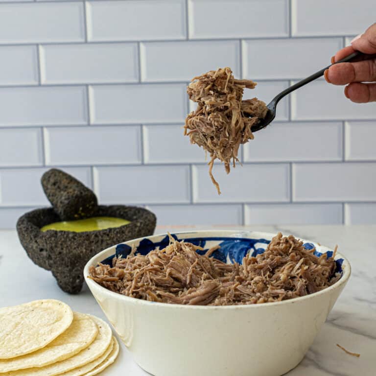 This Carnitas de Puerco recipe uses with pork butt, onion, limes, spices, and ancho chiles. This is the most flavorful Carnitas recipe ever!