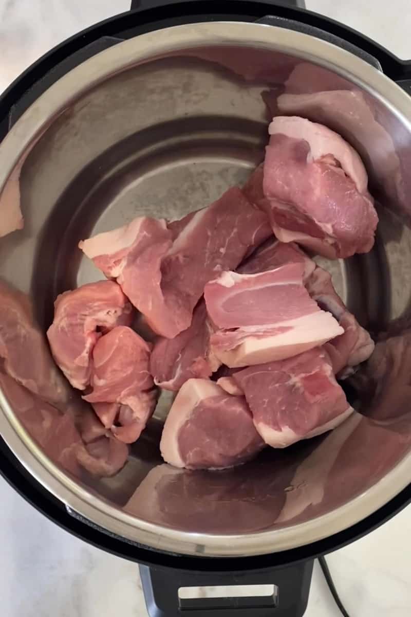 Sazonar el cerdo.  Corte la carne de cerdo en cubos. Frote comino, orégano, sal y pimienta encima del cerdo. Colóquela en la olla a presión.