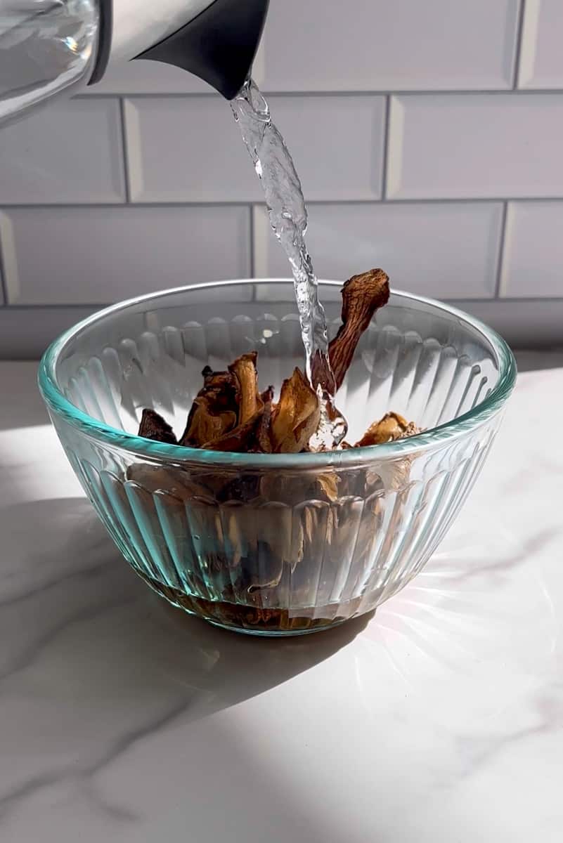 Put the dried porcini mushrooms into a bowl and pour warm water until the mushrooms are covered with hot water. Let them sit in for 15 minutes. Filter with a strainer and a paper towel for maximum straining. Keep the filtered mushroom water. Chop the hydrated porcini mushrooms. 