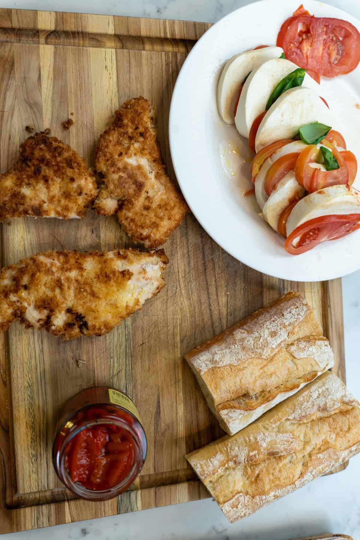 This Chicken Caprese Sandwich with Roasted Peppers is made with chicken cutlets, mozzarella, roasted peppers, vinegar, and a baguette.