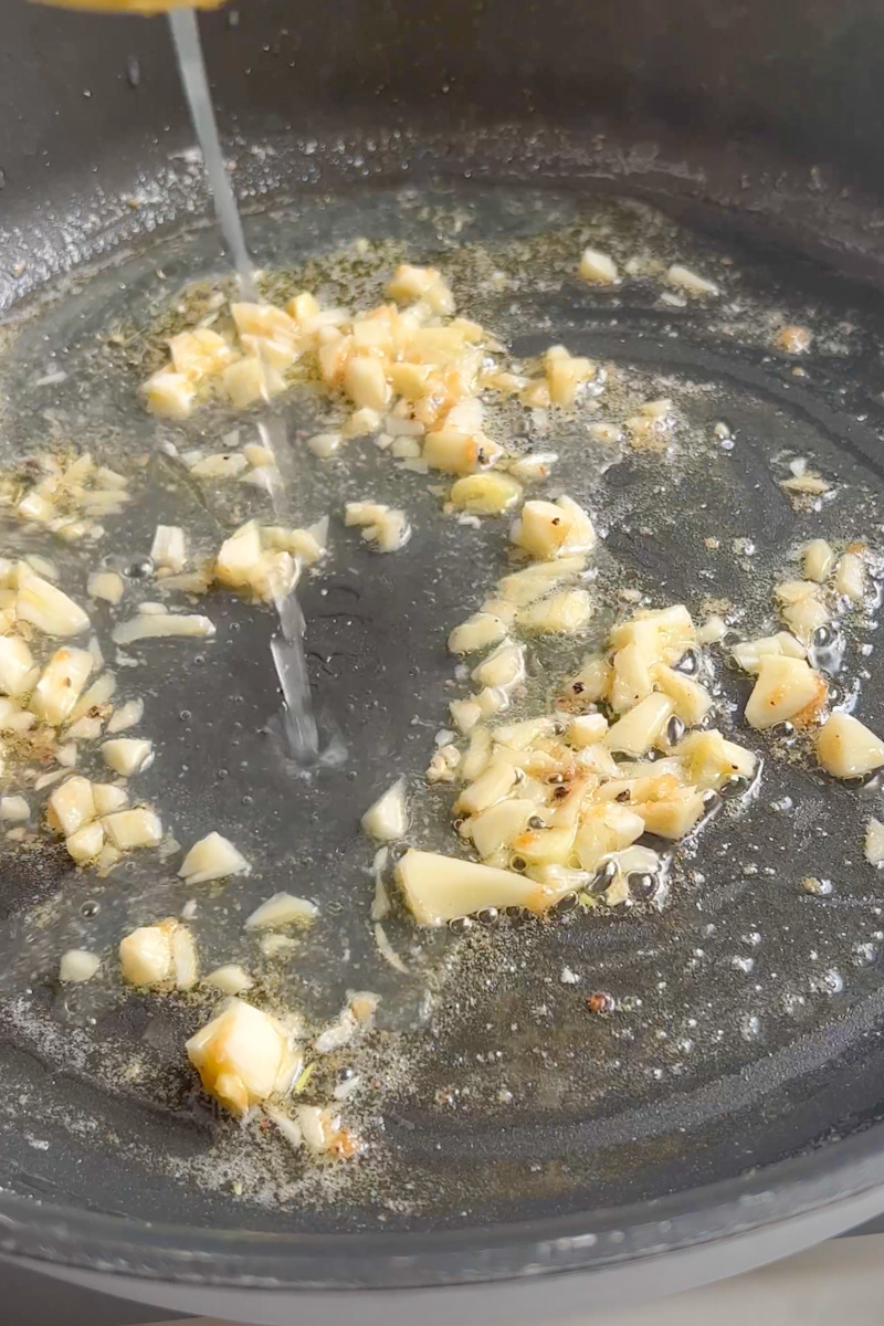 En la misma sartén, agregue el ajo y cocine hasta que esté dorado, aproximadamente 1 minuto. Vierta el jugo de limón. 