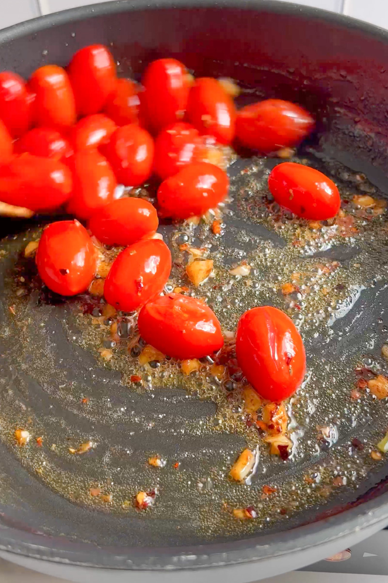 Pour in the white wine then add the tomatoes and cook until they burst, around 5-7 minutes.
