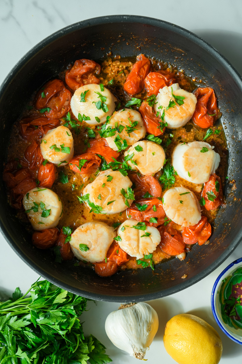 Shut off the heat and add the scallops back in and toss the scallops until fully coated. Garnish with parsley and squeeze lemon juice to your liking. Enjoy these Scallops in Butter Tomato Garlic Sauce (Keto).