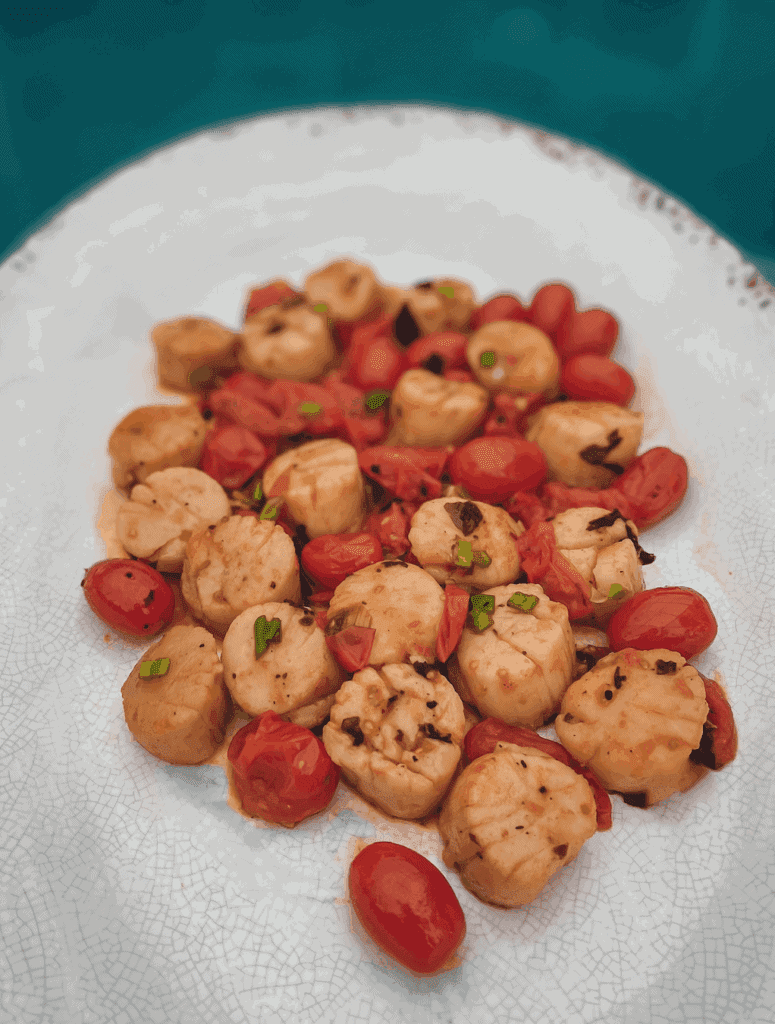 These Creamy Pan Roasted Scallops with Fresh Tomatoes are made with scallops, garlic, oregano, white wine, cherry tomatoes, and lemon.