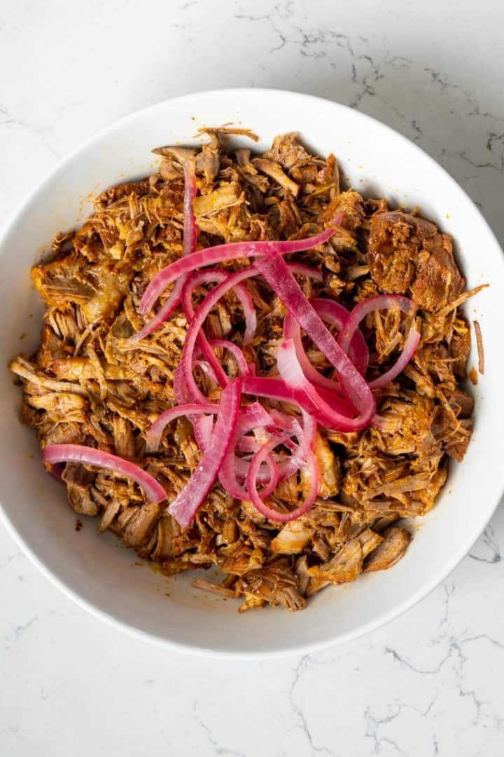 This Cochinita Pibil Instant Pot dish is made with pork shoulder, achiote paste, oranges, limes, pickled onion, cilantro and served on gorditas. 