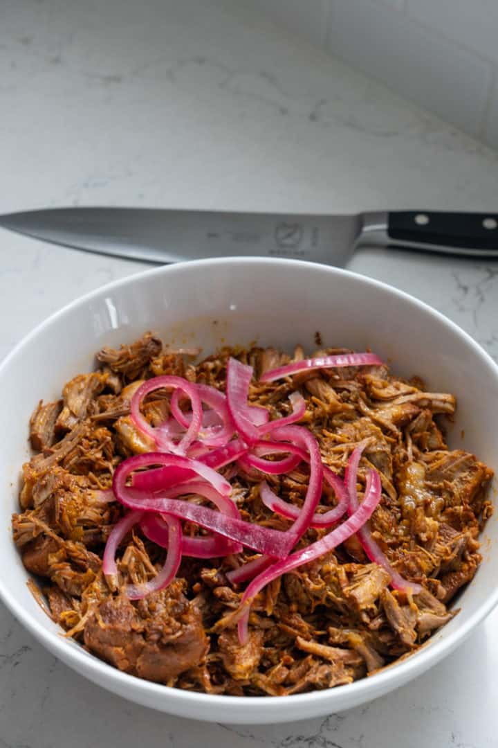 This Cochinita Pibil Instant Pot dish is made with pork shoulder, achiote paste, oranges, limes, pickled onion, cilantro and served on gorditas. 