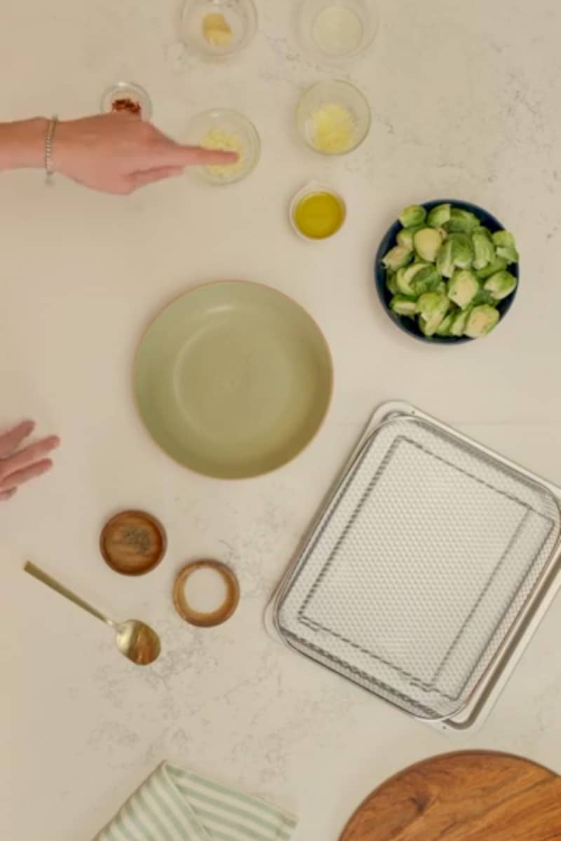 In a large bowl, add the halved brussels sprouts. Drizzle with olive oil and add the red pepper flakes, garlic, lemon juice and zest, Dijon mustard, salt and pepper. Toss to coat.