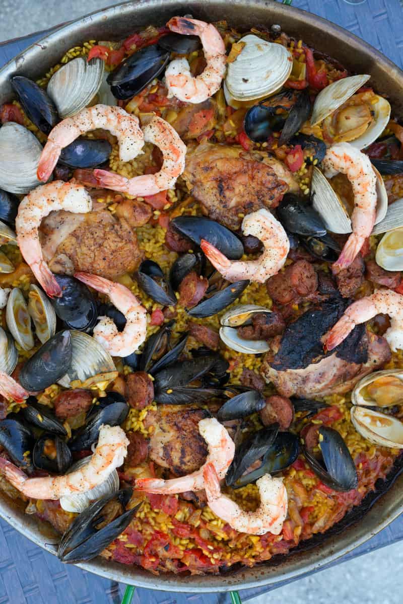 This Spanish Paella Recipe is made saffron, chicken legs, bomba rice, onion, tomato sauce, chorizo, shrimp, mussels, and clams.