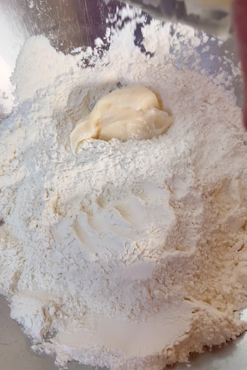 Whisk flour, salt and baking powder. Add pork lard and mix with your hand. Slowly add the hot water and mix until the dough comes together. 