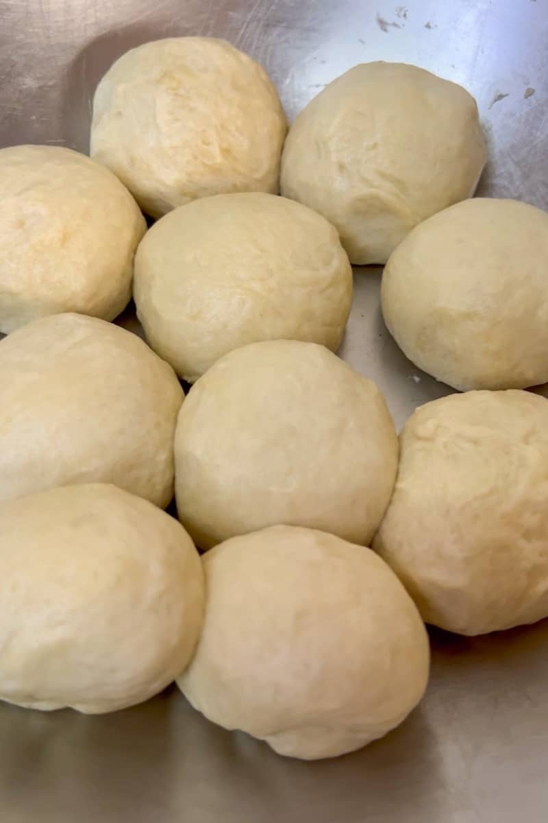 Place on a lightly floured surface and knead a few minutes until smooth and elastic. If you have a Kitchenaid mixer, you can combine everything and use the dough hook the mix. Shape a small amount of dough into a golf ball. Repeat with the rest of the dough. Let the dough balls rest for 20 minutes. 