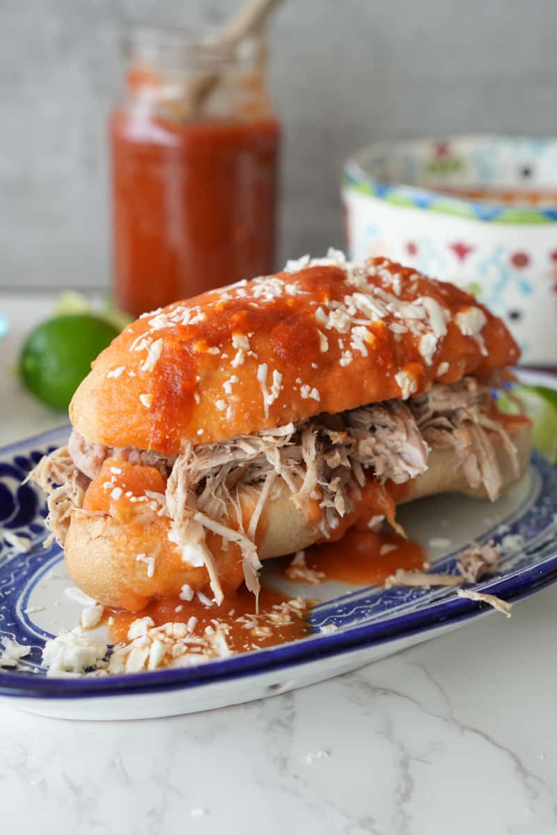This Tortas Ahogadas Recipe is made with carnitas, refried beans, hot sauce, hard rolls and dipped in a tomato sauce. 