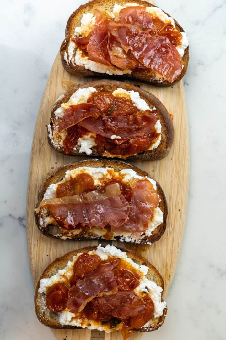This Prosciutto Toast with Honey Roasted Tomatoes and Prosciutto is made with sourdough bread or a baguette, ricotta, lemon, honey, and basil.