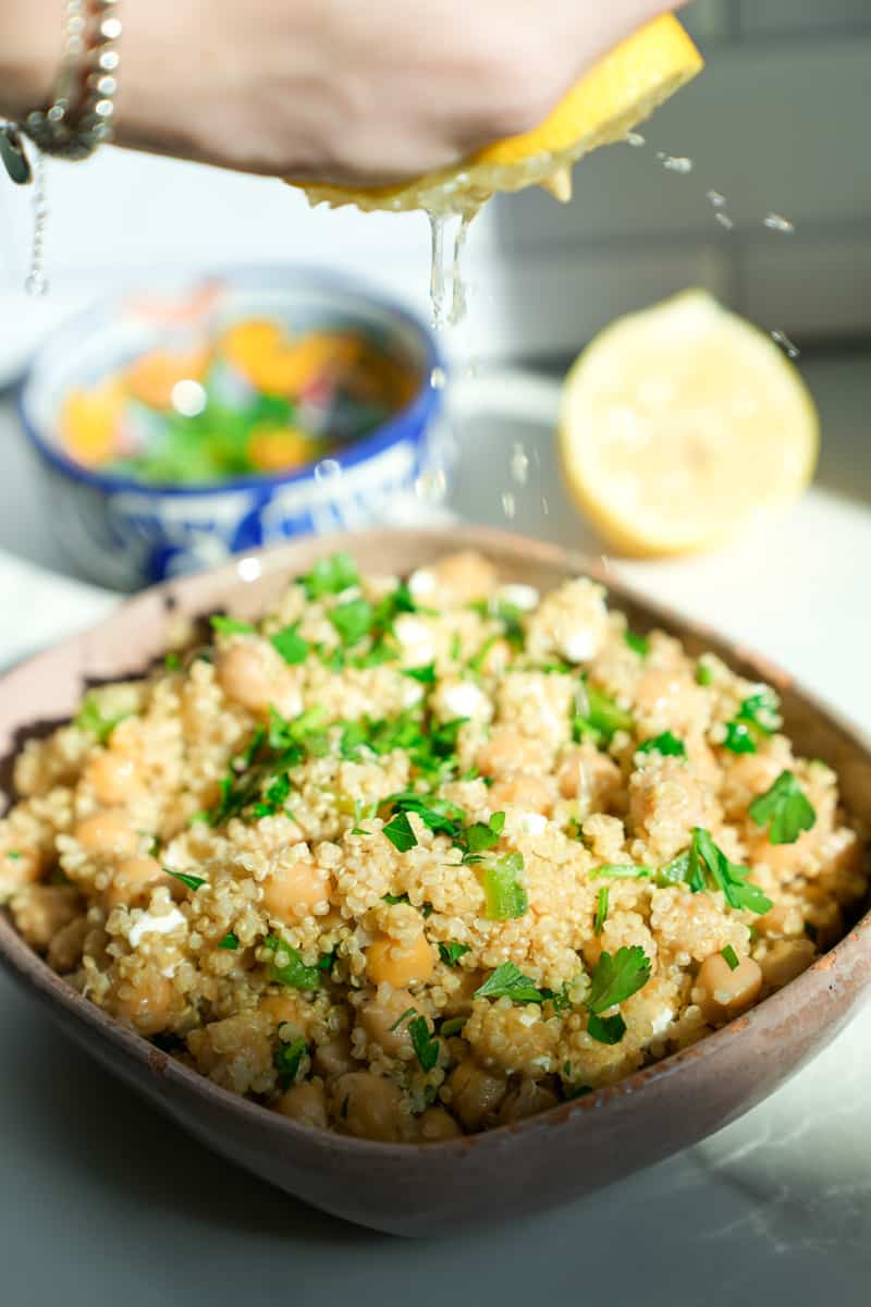 En un tazón, agregue el aceite de oliva, vinagre, jugo de limon y mezcla.

Agregue la quinua cocinada en un tazón grande. Agregue los garbanzos, perejil, feta, y pimiento. Mezcla bien.