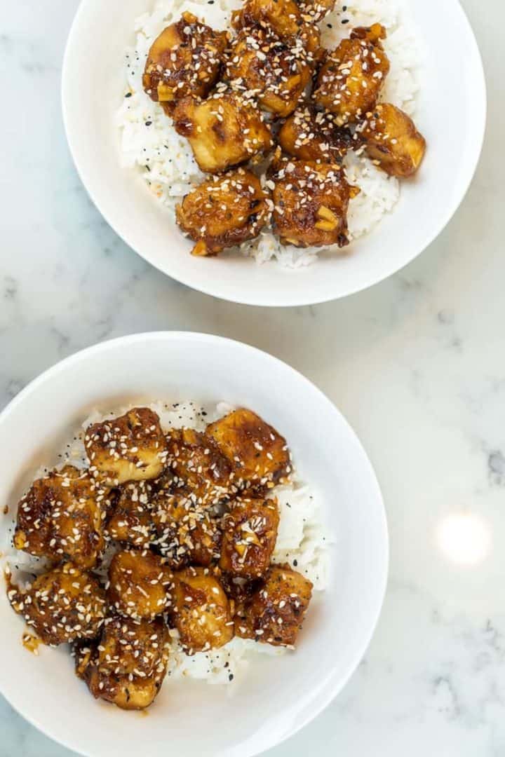 This Ginger Sesame Tofu is made with tofu, sesame oil, soy sauce, maple syrup, ginger, garlic, sriracha, rice wine vinegar, scallions, and sesame seeds.
