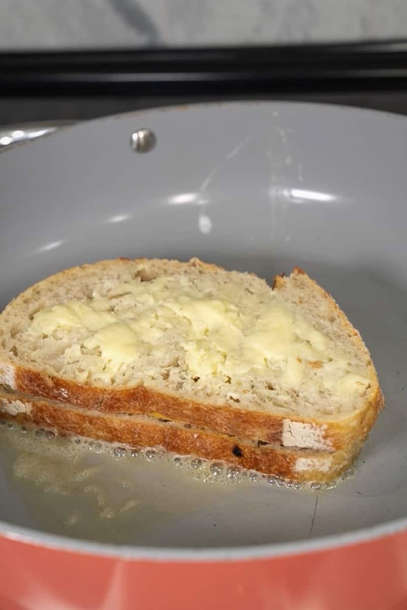 Heat a skillet or griddle over medium-low heat. Place the sandwich in the skillet and cook until the bread is golden brown and the cheese starts to melt, about 3-4 minutes.