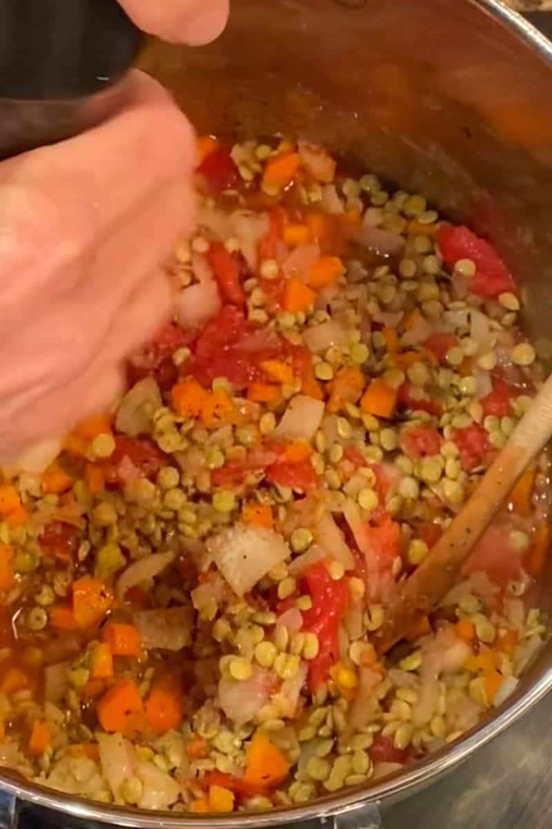 Add the crushed tomatoes and their juices to the pot, along with the chicken or vegetable broth. Stir in the dried lentils and bring the soup to a boil. Reduce the heat to low, cover the pot, and simmer for about 30-40 minutes, or until the lentils are tender.