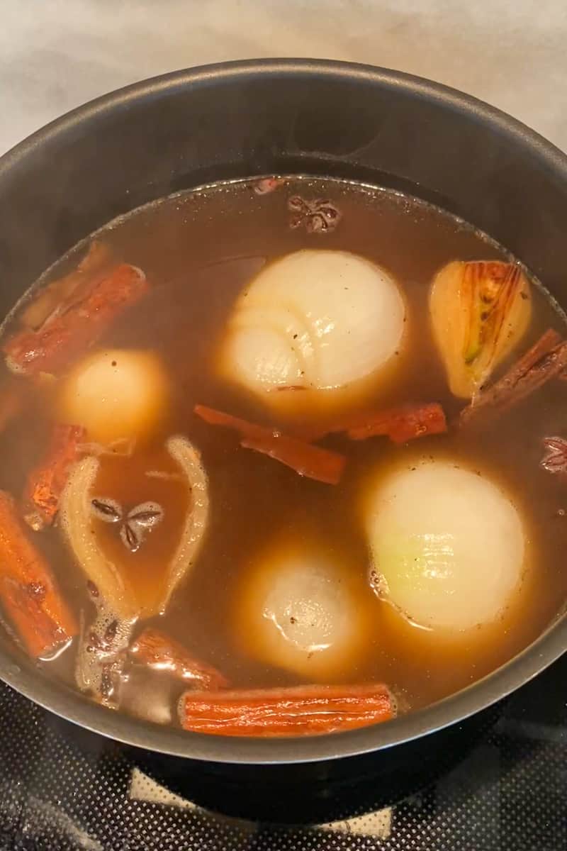 Wipe the pot down and in the same pot on medium high heat, add the anise, cloves and cinnamon for 3 minutes until fragrant. Add the onions and ginger back into the pot as well as the broth and bring to a boil. Reduce heat to medium-low, cover and cook for 30 minutes.