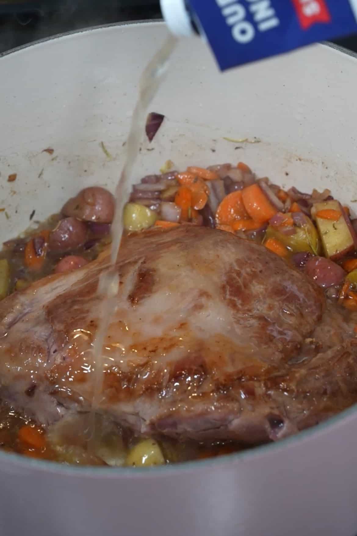 Pour in the chicken broth and red wine (if using). The liquid should come about halfway up the sides of the pork. Add the bay leaves. Cover the pot with a lid and transfer it to the preheated oven. Roast for 1.5 to 2 hours or until the pork is tender and easily pulls apart with a fork.