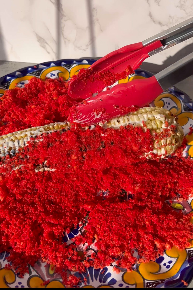 Toss the corn in the Flamin' Hot Cheetos dust. Repeat with the rest. 