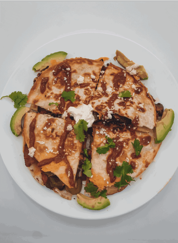 This Portobello and Bacon Quesadillas with Chipotle Aioli is made with chipotle sauce, avocado, flour tortillas, cilantro, and sour cream.