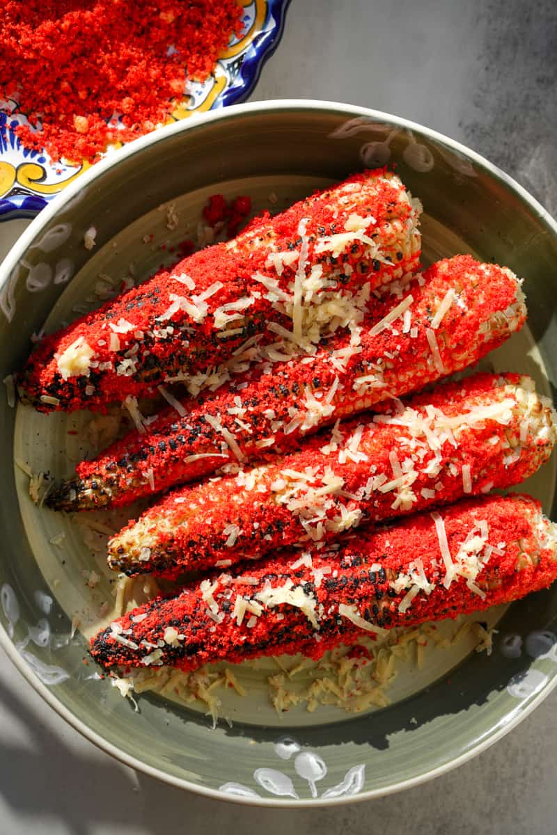 This Flamin Hot Cheetos Corn (Elote) is made with corn, butter, limes, sour cream, mayonnaise, cotija cheese and Flamin Hot Cheetos. 