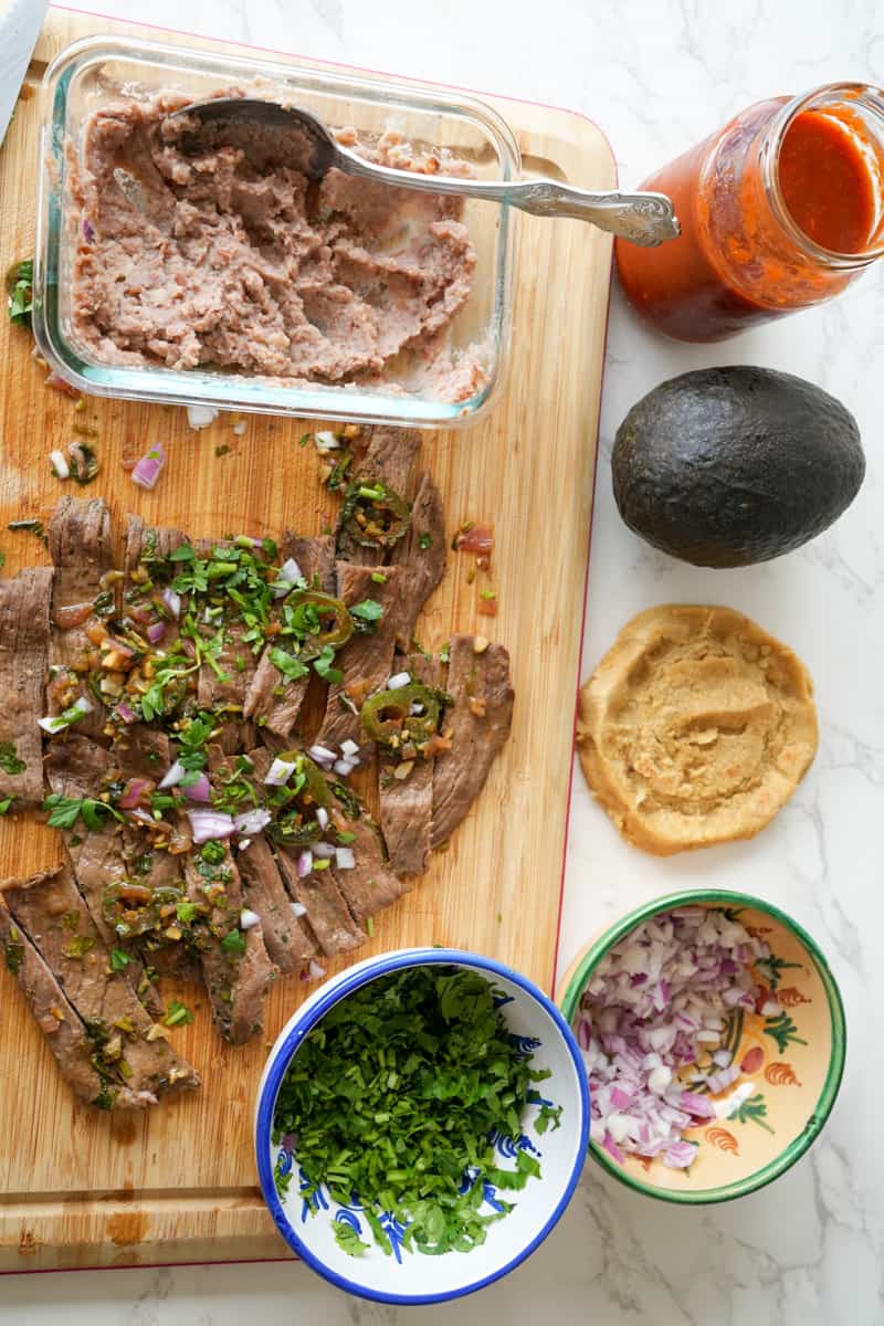 This Mexican Sopes Recipe is made with carne asada, refried beans, maseca, avocado and cotija cheese and cooked to perfection.