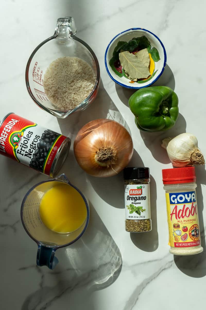 Esta Moros y Cristianos Receta está preparada con arroz, cebolla, pimiento, ajo, adobo, frijoles negros, jugo de naranja y cocinado a fuego lento a la perfección.