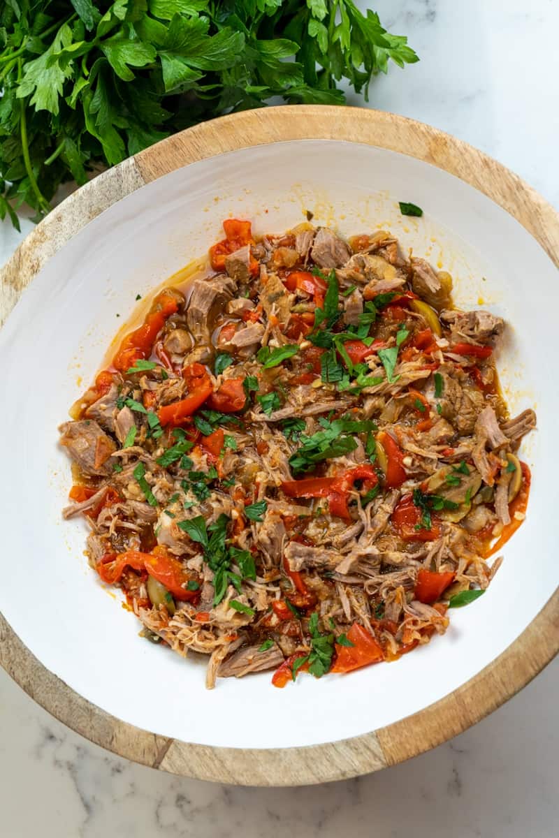 This Instant Pot Ropa Vieja is made with beef round bottom, bell peppers, onions, white wine, broth, tomato sauce, olives and cilantro.