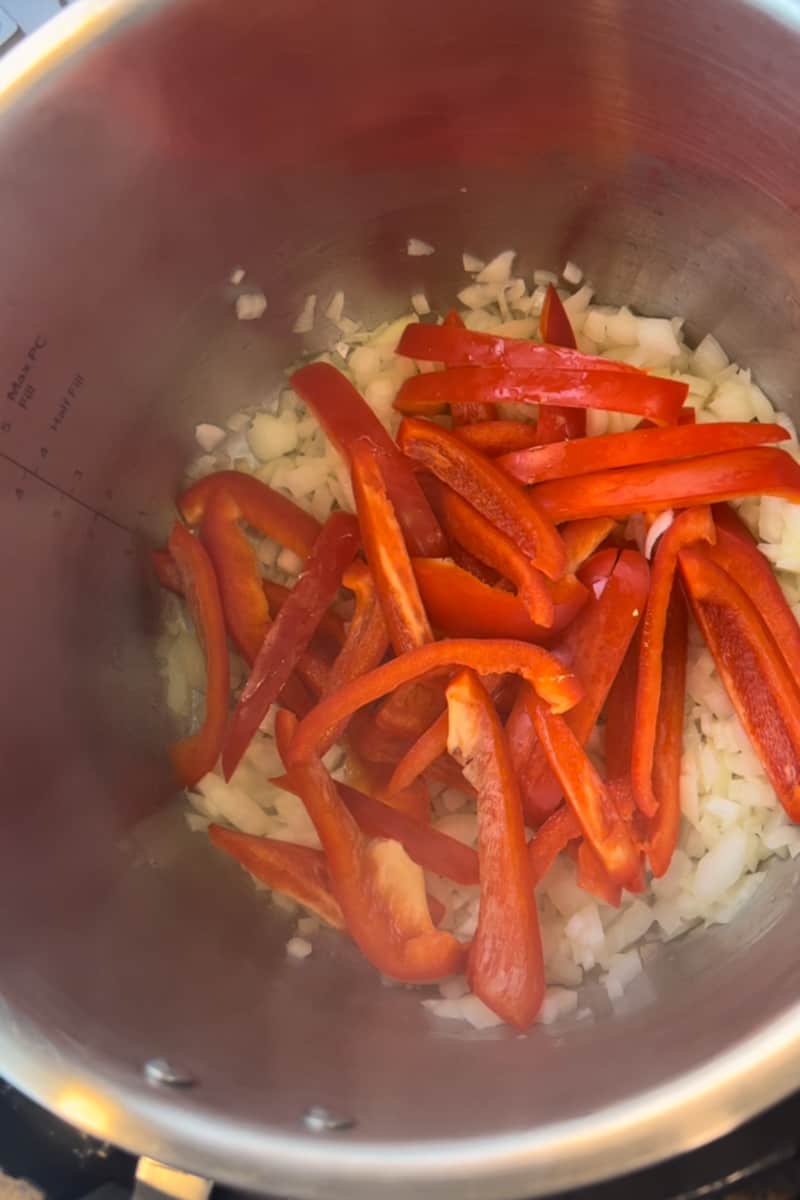 Start by hitting the sauté button for 8 minutes, add oil and wait for it to shimmer. Toss in the onions and bell peppers and toss for 4-6 minutes, until soft.