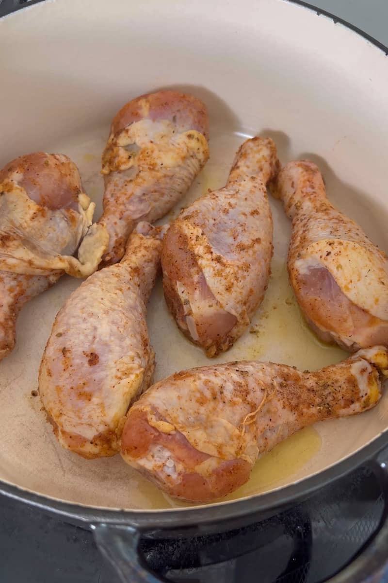 Add olive oil in a large skillet and start by browning the chicken thighs and legs on medium high heat, about 8 minutes total, turning often. Remove the chicken and place on a plate.